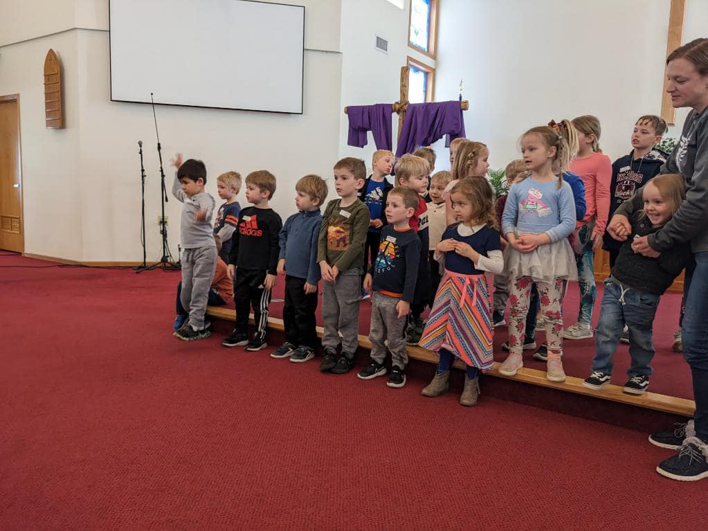 A group of children practicing singing for Easter for Kids