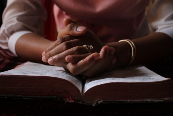 woman praying while in Bible study